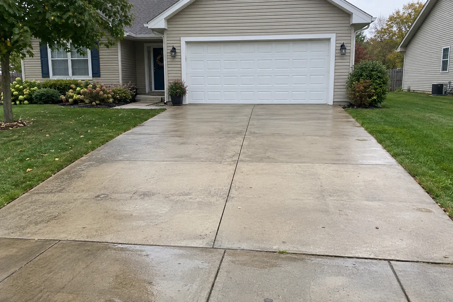 Concrete driveway leading to a modest two-car garage
